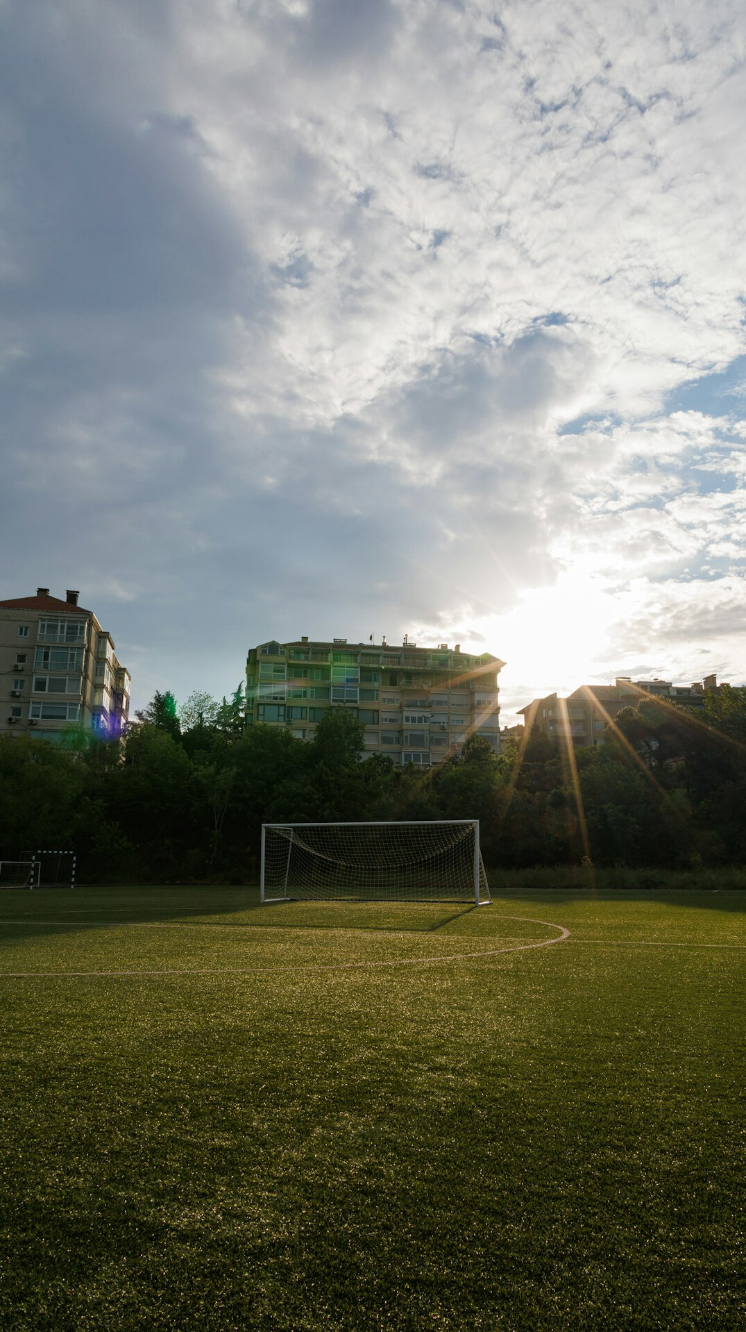 Football stadium with floodlights and green pitch